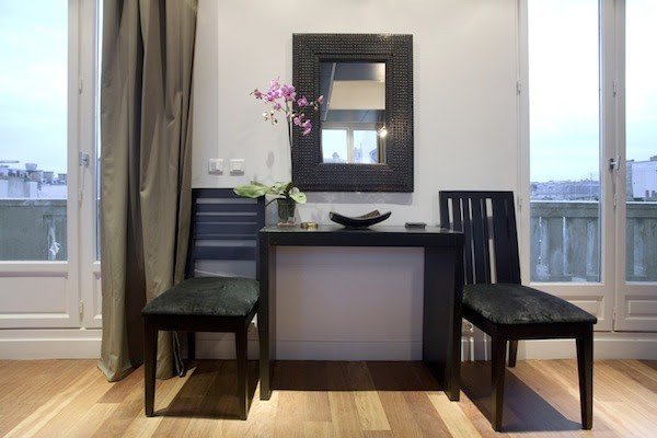 A writing table between two balcony doors.