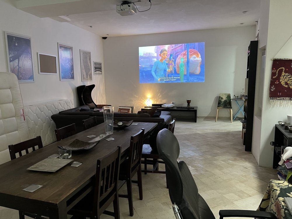 The RDJ lower level dining table facing the lounge with a film projected on the wall.