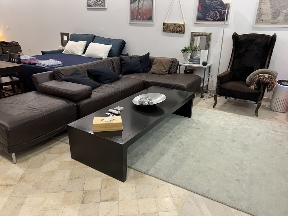 A double bed beside the RDJ lower level lounge with a corner sofa and coffee table.